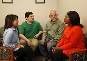 Two men and two women seated in a circle, talking to one another