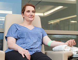 Mujer en una silla donando sangre.